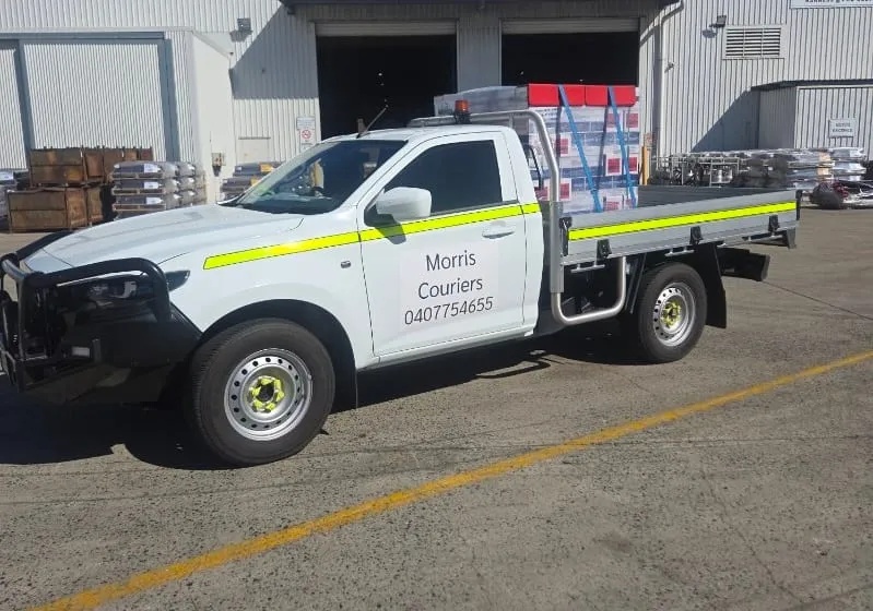 A Morris Couriers ute with freight strapped down on the tray, loaded and ready to leave.